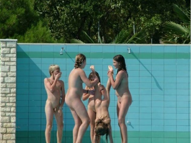 Young nudists bathe under an open shower Young nudists bathe under an open shower